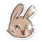 distressed sticker of a cartoon happy rabbit face