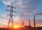 Distribution electric substation with power lines and transformers, at sunset