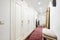 Distributor corridor of a house with an oak wooden corridor, a built-in wardrobe with white wooden doors along the entire length