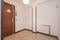 Distributor hallway with light brown terrazzo floors, wood carpentry on the doors and white aluminum radiator