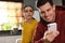 Distrustful woman peering into boyfriend`s smartphone. Jealousy in relationship