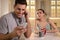 Distrustful woman peering into boyfriend`s smartphone. Jealousy in relationship