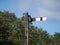 Disused train signal with a blue sky and trees