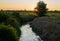 A ditch at the meadows next to the river Hunte Germany during sunset