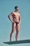 Dive right in. Full length shot of a handsome young male athlete standing on a diving board outside.