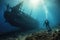 A diver explore a ship wreck underwater at the bottom of the sea.