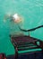 Diver in old diving suit immerses in water