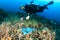 Diver swimming over a discarded plastic bag on a reef