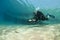 Diver on underwater scooter with sting ray