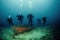 Diver underwater view of floating scuba divers on the background of the wreckage of the boat.