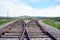 Diverging train tracks with wild west mountains in background