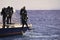 Divers jump from boat in blue sea water in Egypt