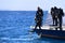 Divers jump from boat in blue sea water in Egypt
