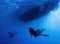 Divers Return To Boat Underwater with Boat on Surface in Silhouette