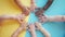 Diverse baby hands forming a circle on a colorful background.