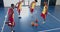 Diverse basketball players practice in an indoor court