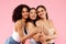 Diverse beauty. Portrait of happy black, asian and caucasian ladies posing and smiling at camera over pink background