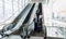 Diverse business travellers coming down an escalator