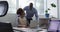 Diverse businessman and businesswoman talking, woman using laptop in office