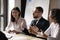 Diverse businesswomen laughing at colleague joke at corporate meeting