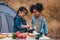 Diverse children of asian and african american friends having fun palying cooking together during going camping countryside