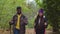 Diverse couple backpackers hiking on forest path