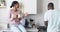 A diverse couple enjoys a conversation in a modern kitchen