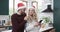 Diverse couple wearing santa hats using smartphone in kitchen, in slow motion