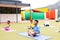 Diverse elementary schoolchildren practicing yoga meditation in schoolyard, copy space