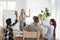 Diverse employees raise hands participating in teambuilding