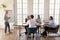 Diverse employees team listening to middle aged businesswoman at meeting