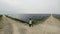 Diverse engineers in special uniform walking through solar farm. The rows of solar batteries. Green energy concept