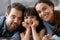 Diverse family lying on warm floor looking at camera