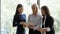 Diverse female colleagues brainstorm working on tablet in office