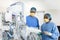 Diverse female and male surgeon studying technical equipment in operating theatre, copy space