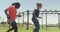 Diverse fit group running through tyres in the sun on obstacle course