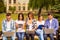 Diverse five joyful friends study up Ñ„Ñ‚Ð² sitting on bench