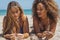 Diverse girl chatting on sandy shoreline