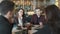 Diverse group of business coworkers sitting at a table in restaurant. Colleagues discussing working situation. Concept