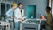 Diverse group of employees playing foosball in office while colleagues are working in background