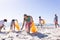 A diverse group of friends are cleaning up the beach and collecting trash with copy space