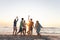 Diverse group of friends enjoy a beach sunset