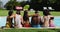 Diverse group of friends sitting in a row at a pool party