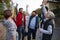 Diverse group of happy community service volunteers raising hands together outdoors in street