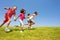 Diverse group of happy kids run in park hold hands