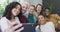 Diverse group of happy male and female friends smiling and taking selfie in living room