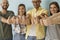 Diverse group of happy young men and women smiling and giving thumbs up together