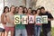 Diverse group holding sign with letters Share