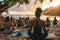 A diverse group of individuals engaging in yoga poses on a sandy beach while surrounded by the ocean waves, A yoga class taking