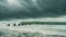 A diverse group of individuals stand on the sandy shore of a beach, overlooking the vast expanse of the ocean, A line of surfers